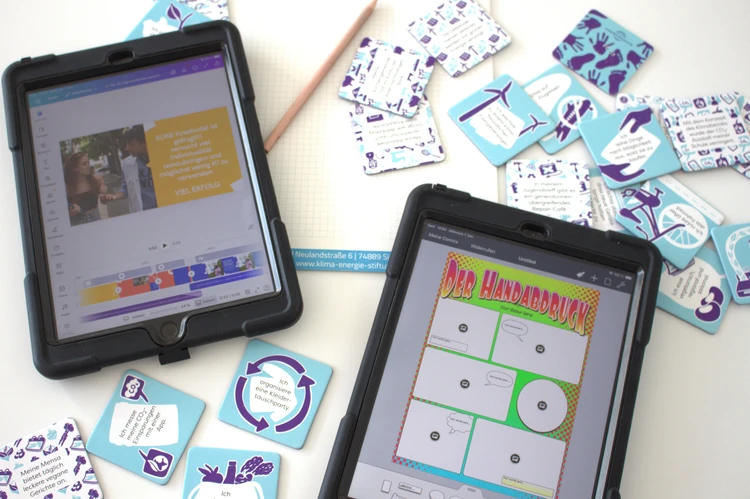 zwei Tablets und mit Workshopinhalten auf Display und Memorykarten im Hintergrund.