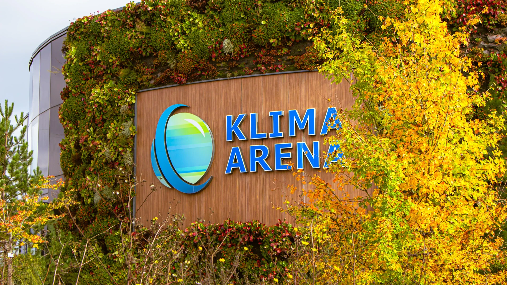 Au&szlig;enwand der Klima Arena mit herbstlichem Baum im Vordergrund