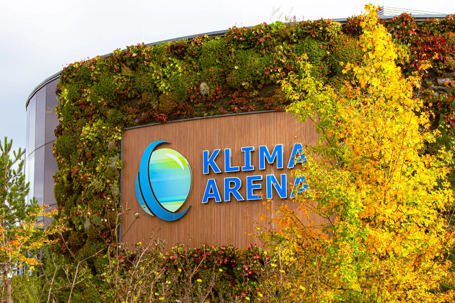 Au&szlig;enwand der Klima Arena mit herbstlichem Baum im Vordergrund