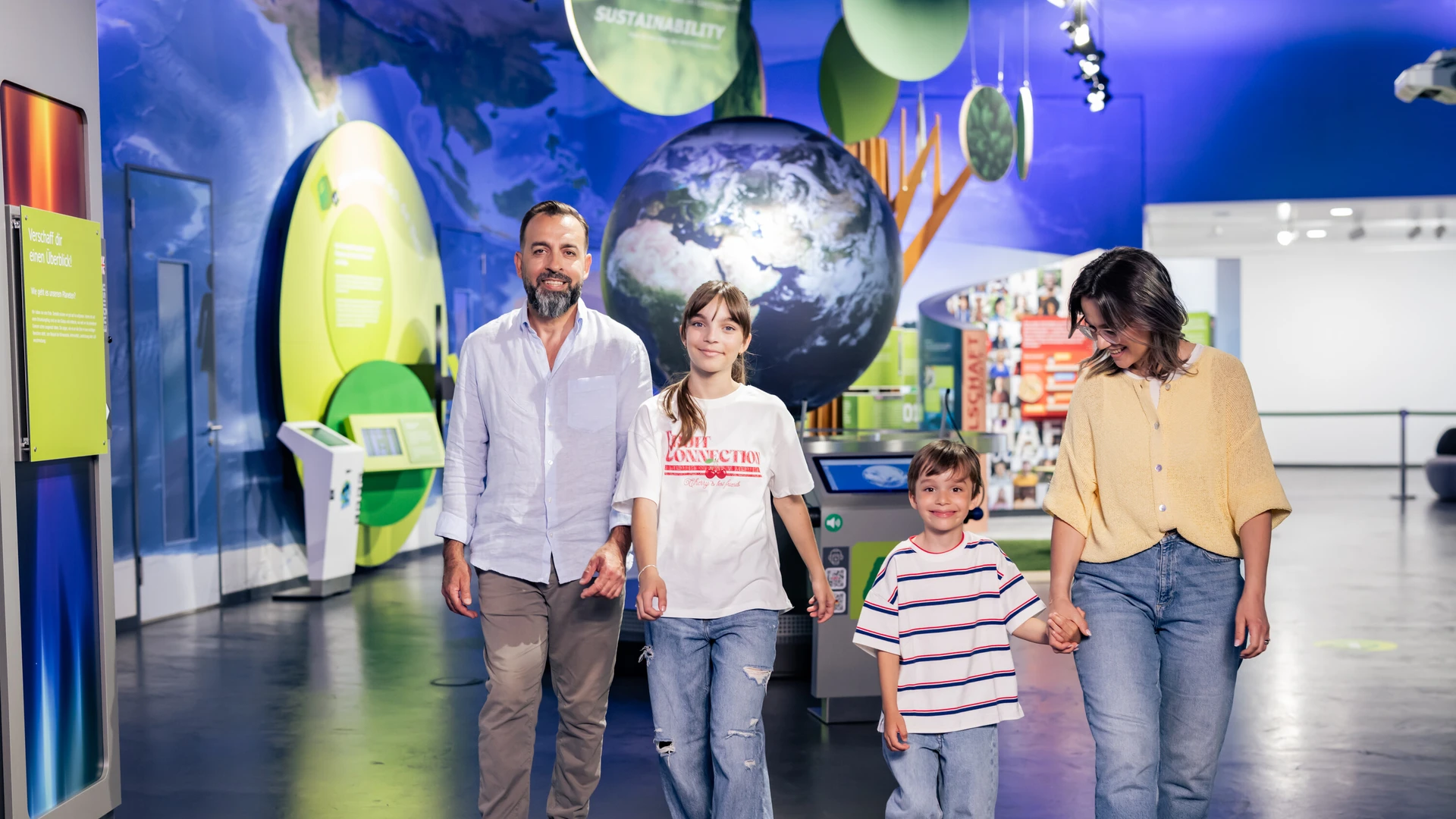 Familie l&auml;uft vor dem Globuns in der KLIMA ARENA.