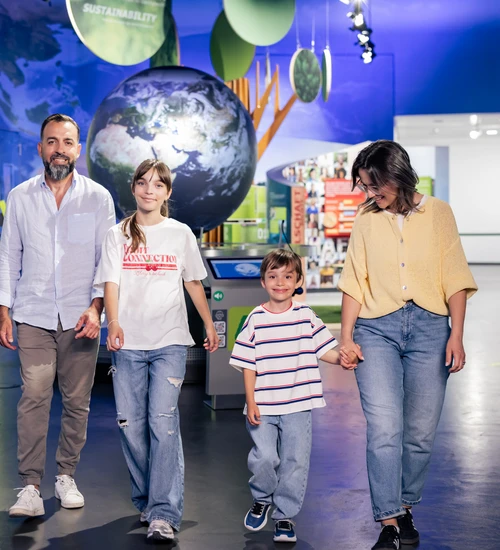Familie l&auml;uft vor dem Globuns in der KLIMA ARENA.